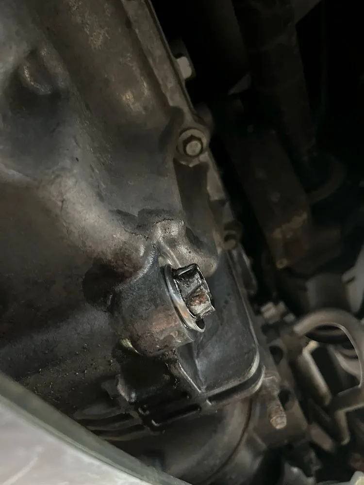 Close-up of an oil drain plug under a car